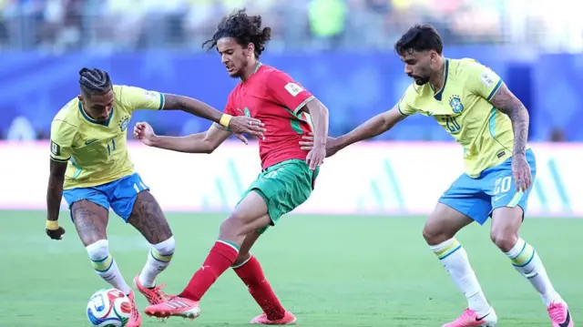 Ayyoub Bouaddi holds off the challenge of Brazil players