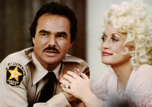 Dolly Parton pictured holding Burt Reynolds hand