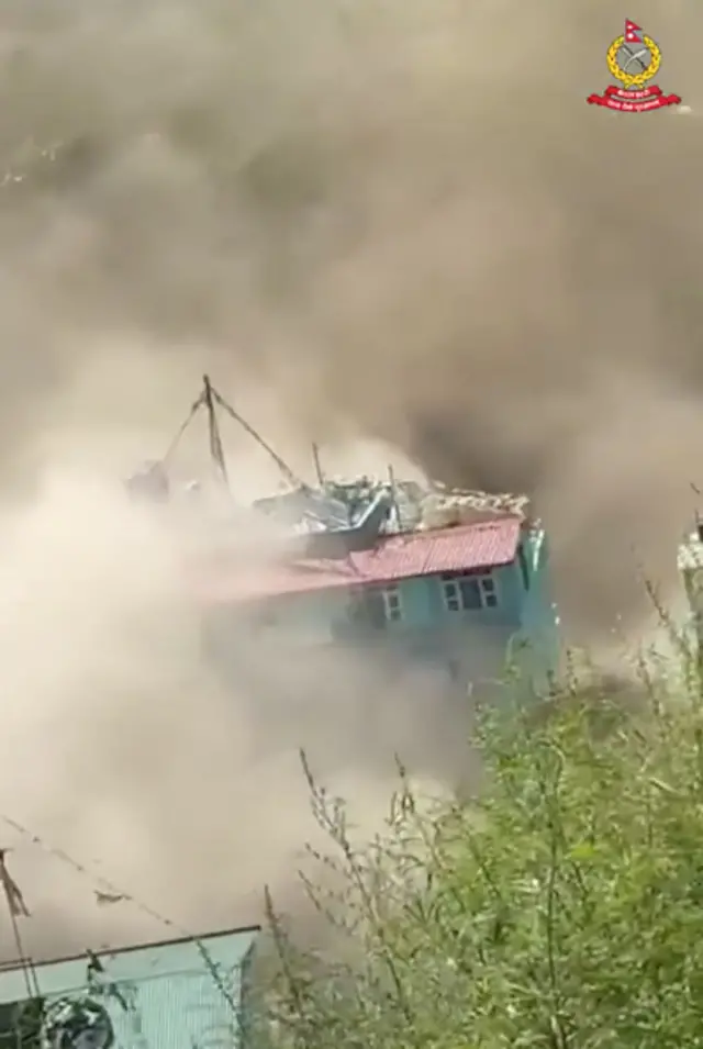 A two storey building is almost entirely submerged by brown water