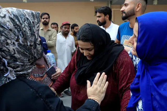 Samiullah, father of a newborn victim, is consoled following a deadly fire at the Pakistan Institute of Medical Sciences (PIMS) hospital in Islamaba