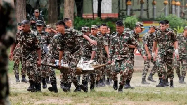 Soldiers are shown carrying a person on a stretcher.