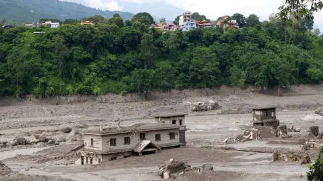 Floodwaters sweep through Trishuli Bazar following a flash flood, in Nuwakot district, Nepal