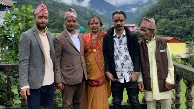 Pramod Poudel's family is shown outdoors on a deck