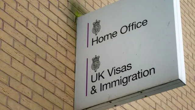 A sign on a wall saying Home Office UK Visas and Immigration