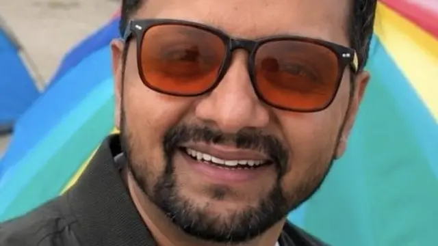 Prabhath Sajeepa is pictured wearing glasses and smiling against a colourful tent.