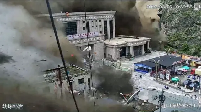 A massive wall of mud and water is shown enveloping the border crossing buildings, which are at least six storeys high.