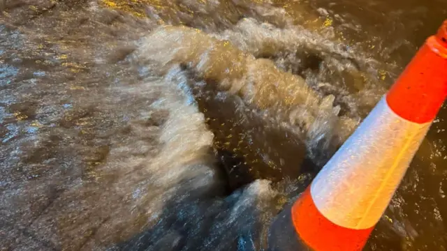 Water erupting from the road and overflowing
