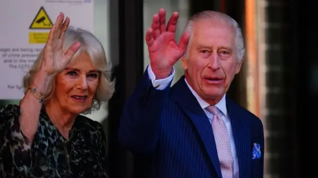 King Charles and Queen Camilla are shown outside, waving as they arrive at an event.