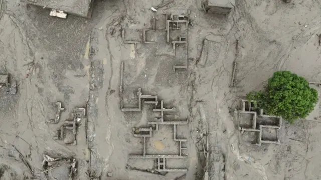 A drone view shows mud covering buildings following a flash flood in Trishuli