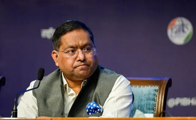 India’s foreign ministry spokesperson Randhir Jaiswal sitting at a wooden table wearing a grey vest over a white shirt