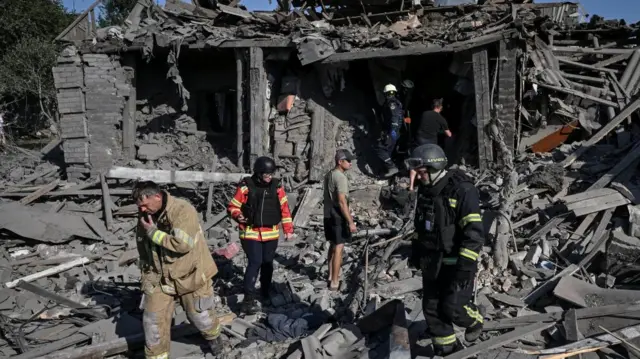 Rescuers work at Ukrainian site of houses destroyed yesterday by a Russian air strike