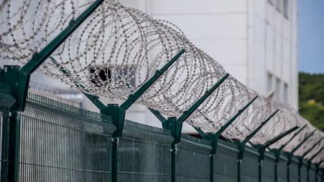 A barbed wire fence outside a prison