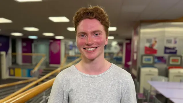 Gulliver Rowntree wearing a grey top and smiling at the camera.