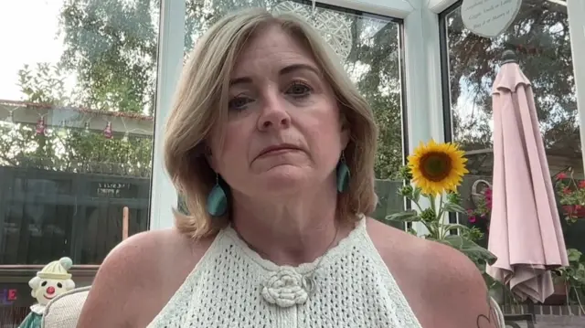 Woman with blonde hair in a conservatory