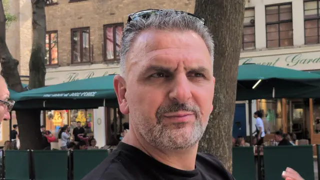 A man looking off to the side in front of a restaurant