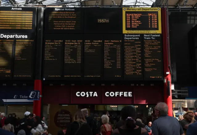An arrivals and departures board shows delays and cancelations at Lime Street railway station in Liverpool