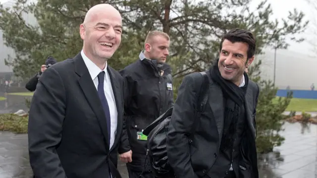 Luis Figo and Gianni Infantino walking together and smiling