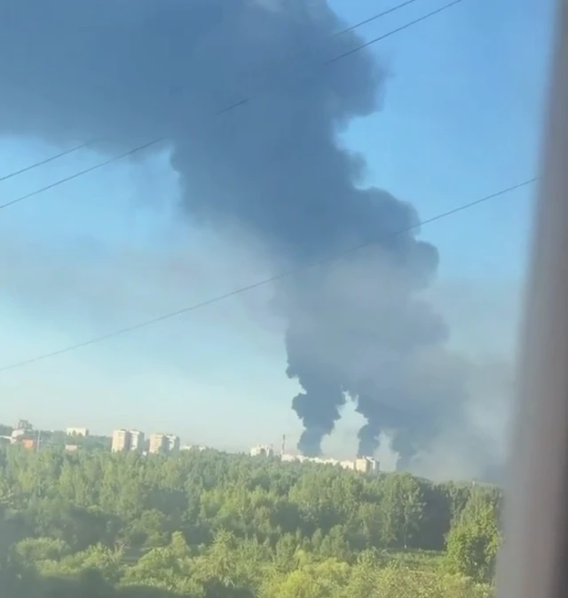 Three large smoke plumes rising from a refinery