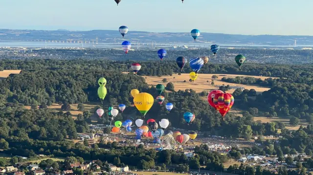 Lots of balloons seen from above, taking off from the Fiesta site at Ashton Court.
