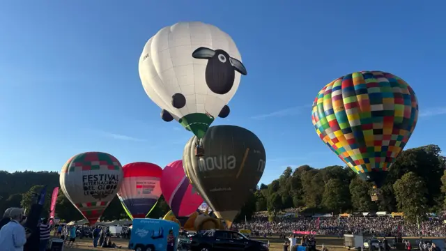 A Shaun the Sheep Aardman balloon rises above others on the ground