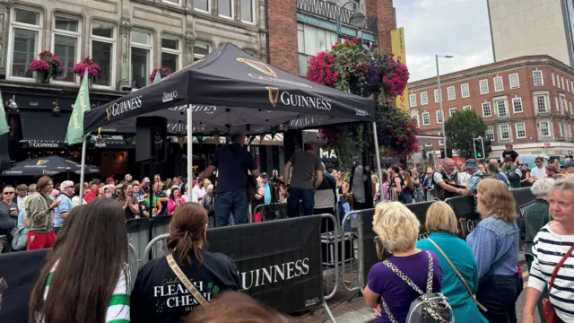 Crowds watching a band on stage in Belfast