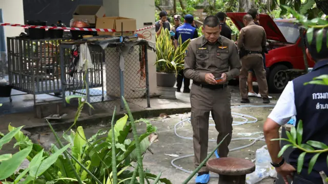 Officials in brown uniforms gather and survey the residence