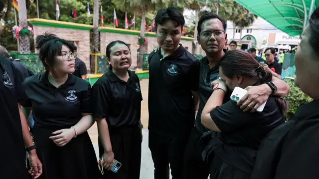 People in black t-shirts looking distraught
