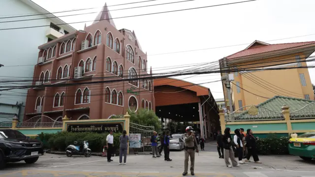 A wide view of the Debsirin Nonthaburi School as officials and families stand outside