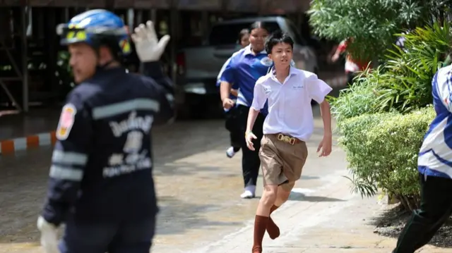 A boy in school uniform runs
