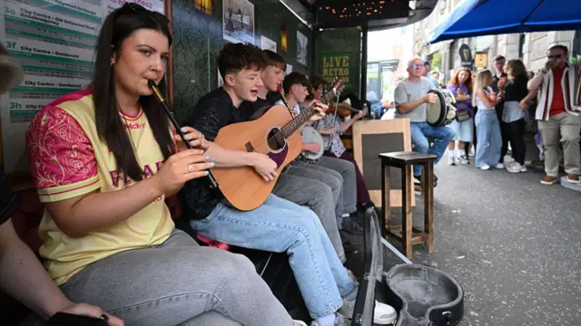 People play music at a bus stop