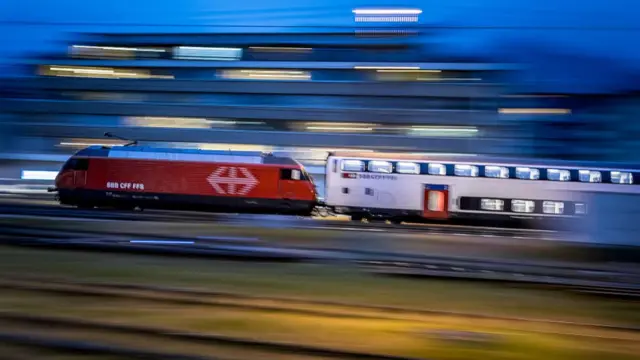 This slow shutter photograph shows a Swiss Federal Railways (SBB / CFF / FFS) train running on railroad tracks in Sion