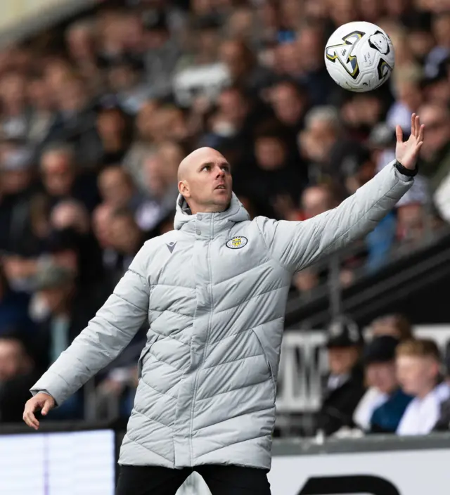 Craig McLeish reaches for a ball in his big jacket