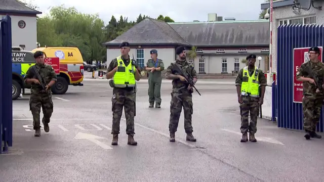 Six soldiers stand guard inside an open gate