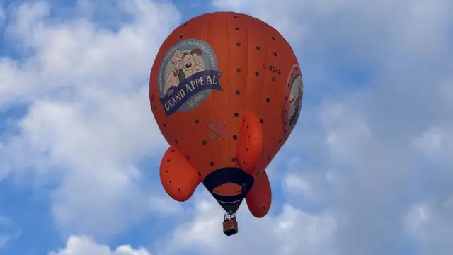An orange balloon with the Grand Appeal logo on it.