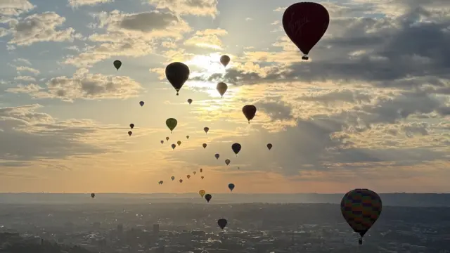 Balloons are silhouetted against the morning sky over Bristol