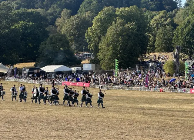 Pipers wearing Full Highland Dress walk along Ashton Court Estate.