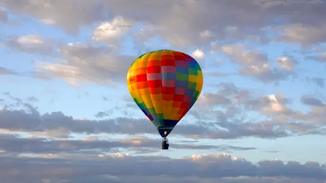 A colourful balloon is in the sky.