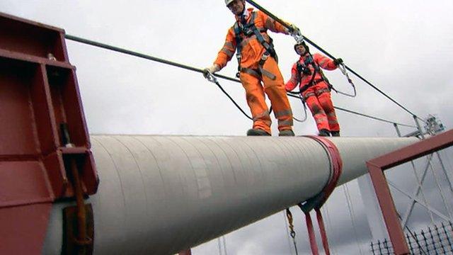 People in safety harnesses inspect the Forth Road Bridge