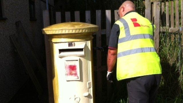 The post box being painted gold on Saturday in Tredegar