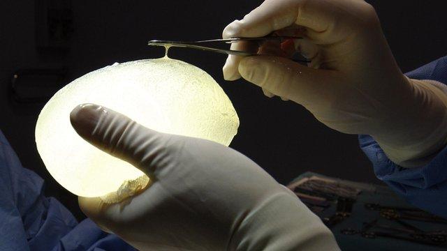 A surgeon holds a defective silicone PIP gel breast implant