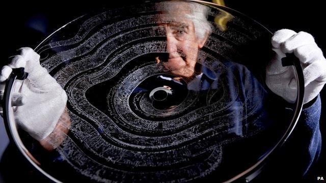 Frank Grenier holds his glass dish engraved with the Bayeux Tapestry