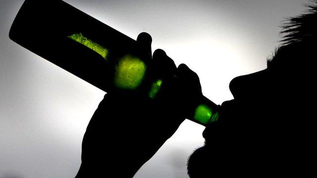 Silhouette of man drinking from bottle