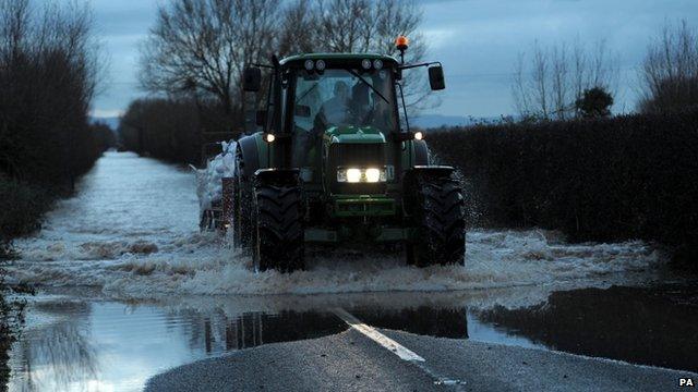 A tractor on a flooded road near Moorland, Somerset