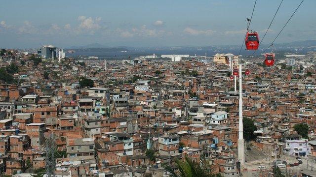 Cable cars travel above the Complexo do Alemao shanty town in Rio de Janeiro