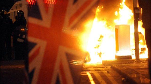 Union flag in front of riot fire