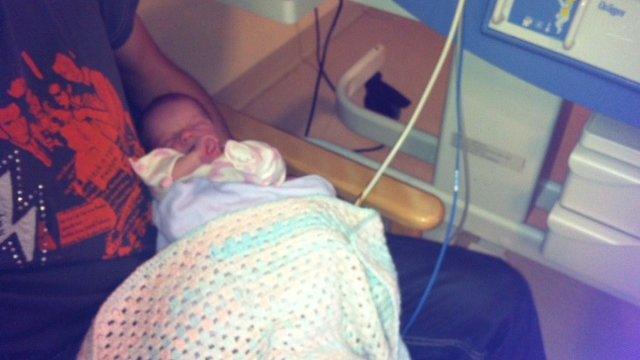 Newborn baby near her cot on paediatric cardiac ward