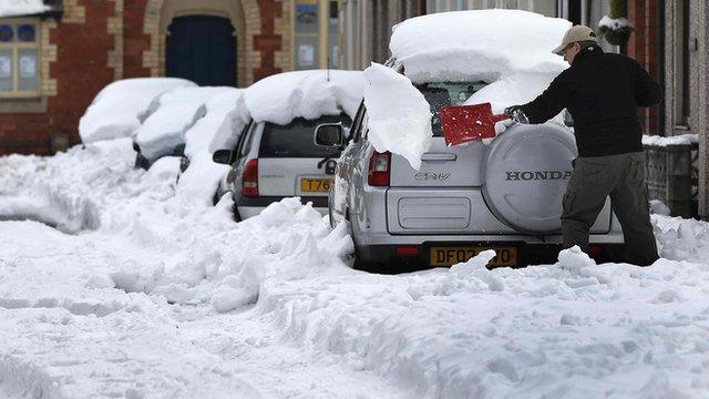 A man clears snow from his car in Llangollen, north Wales