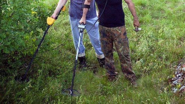 People metal detecting