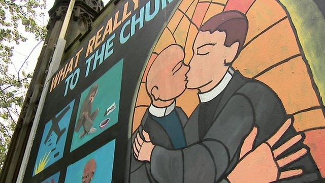 A cartoon poster of two male ministers kissing