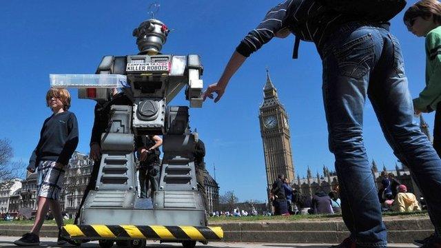 People look at a mock "killer robot" in central London - part of a protest calling for a ban on such weapons in London on 23 April 2013